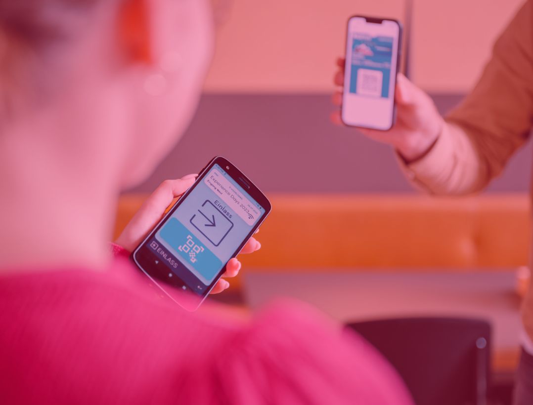 Eine Person scannt ein Wallet Ticket auf einem Smartphone mit dem mobilen Funkhandscanner von ADITUS